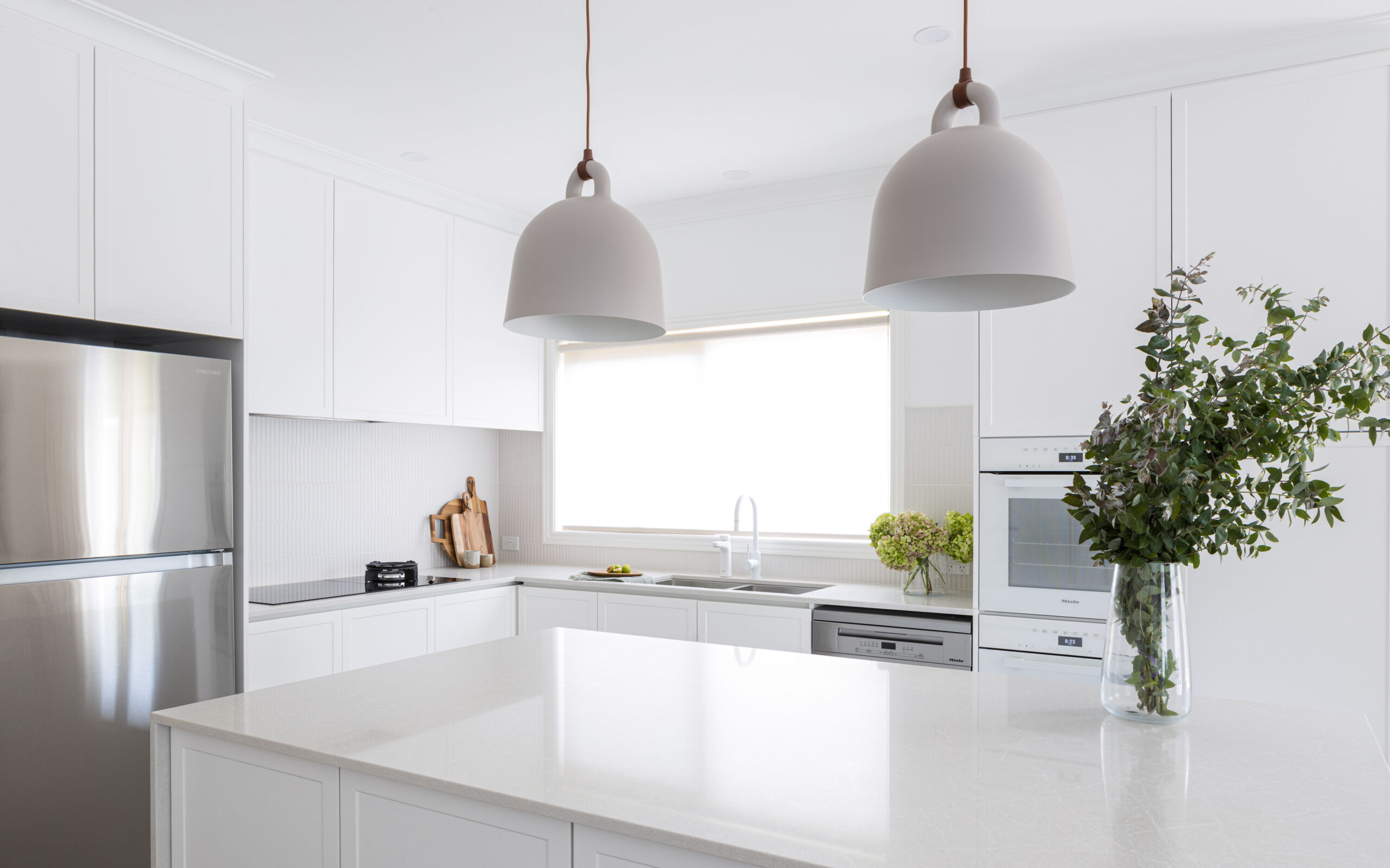 Bell pendant lights hanging over island bench in our Balwyn kitchen renovation
