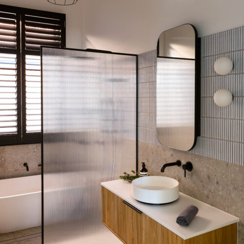 Bathroom design in Yarraville with fluted timber vanity & fluted glass shower screen