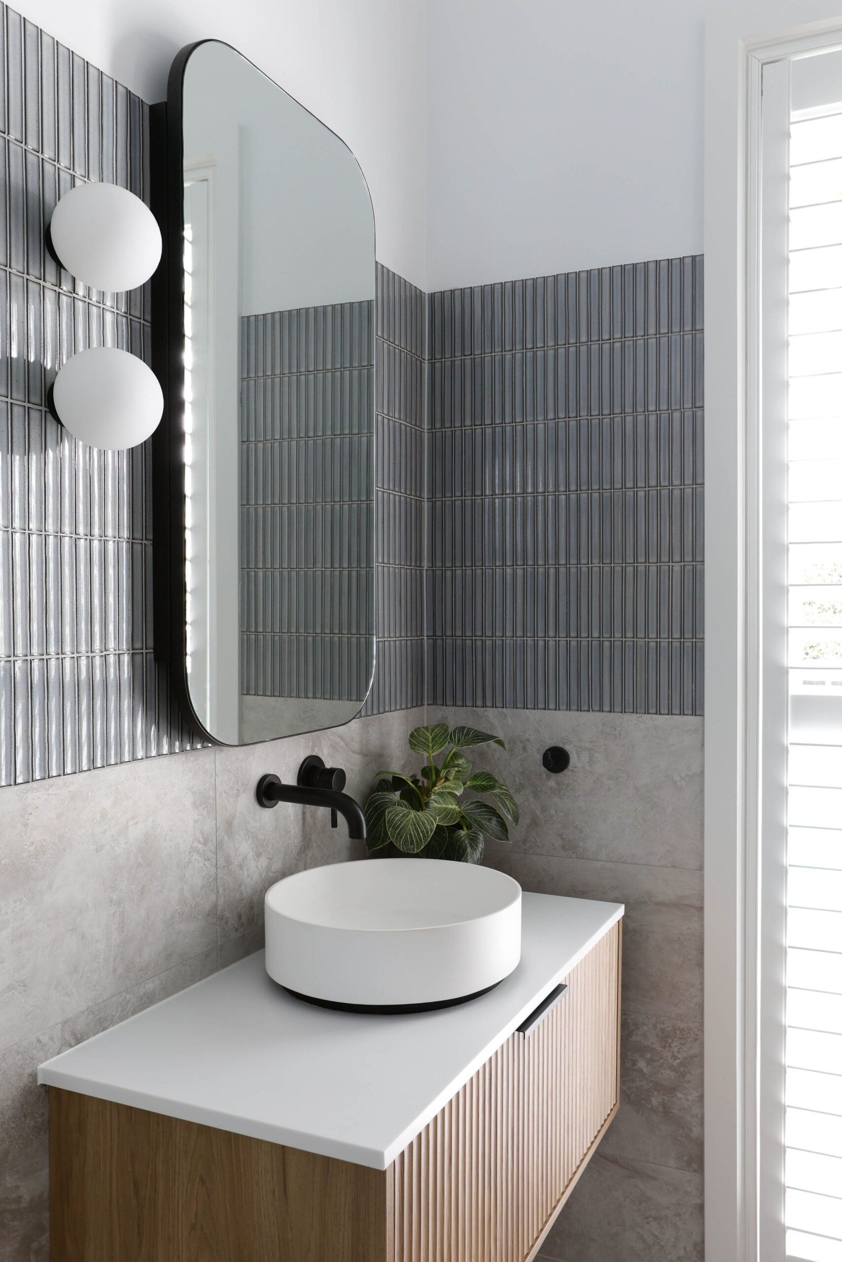 Yarraville ensuite with fluted timber vanity unit, kit kat tiles, oval mirror cabinet and round ball wall lights