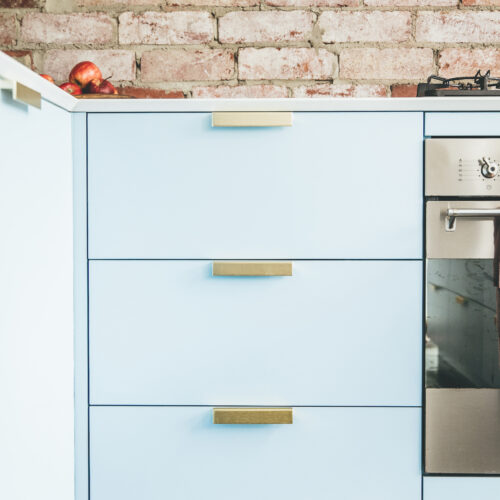 Light blue cabinetry with brass handle