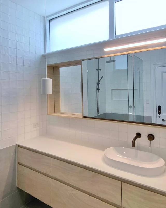 🪄 A nice little refresh recently finished.

The grey floor tile wraps up the wall in line with the vanity creating a datum line through the room. 

Above this sits a handmade white square tile which gives a lovely textured appearance despite the minimalist approach.

Custom joinery in Laminex Raw Birchply paired with Antique Brass tapware by Yabby adds just the right amount of warmth to the palette. 

#bathroom #antiquebrass #laminex #yabby #bathroomrenovation #bathroomdesigns #whitetiles